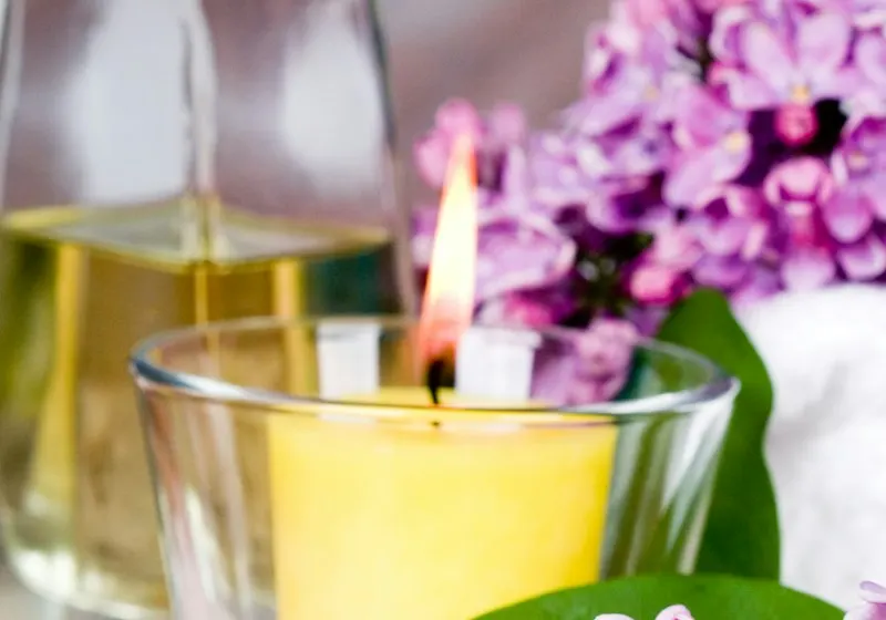 Vela encendida, aceite y flores lila para el Ritual PranaDevi