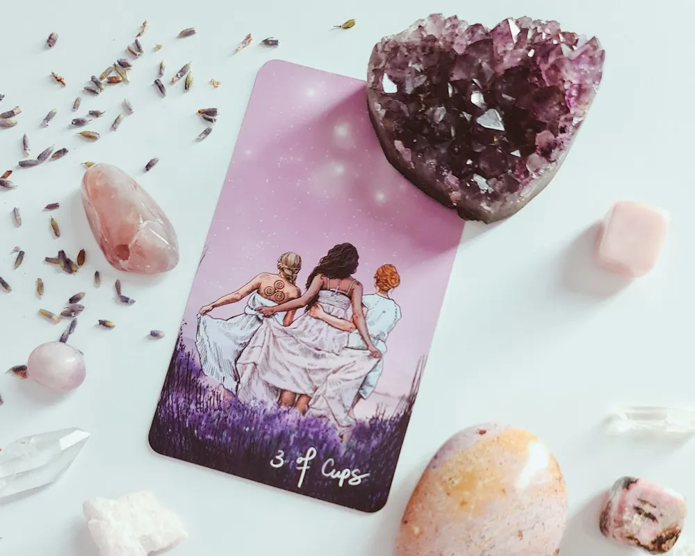 Carta de tarot en tonos lila rodeada de amatista y cuarzos